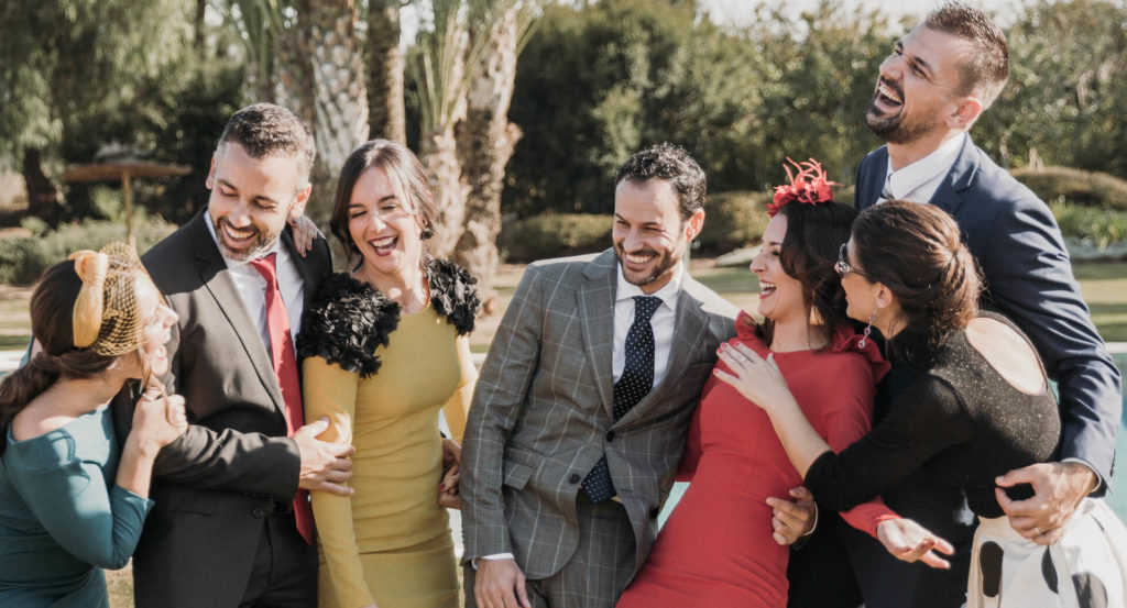 grupo de amigos invitados a una boda en el real club de golf de sevilla y vestidos con trajes y vestidos de colores otoñales