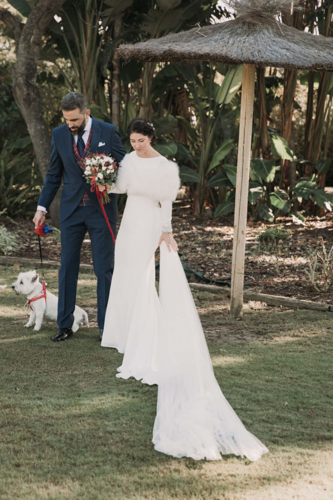 novios en una boda en los jardines del real club de golf de sevilla con su mascota, un pequeño perro blanco