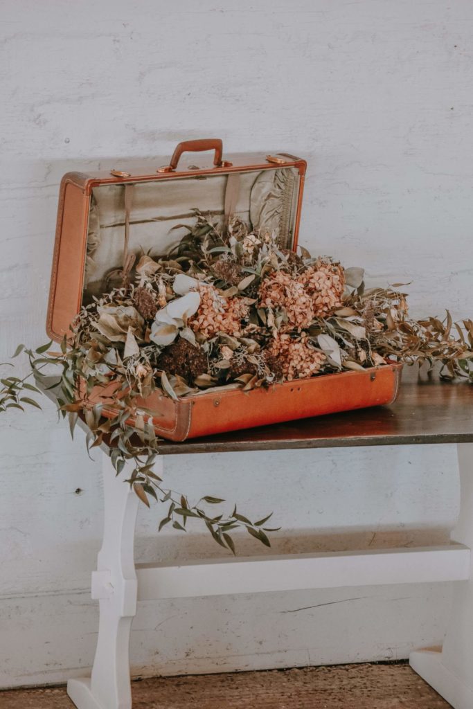 maleta antigua llena de flores secas para la decoración ecológica de una boda de la wedding planner de sevilla flory ferreras