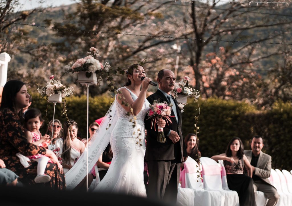 novia cantando en la entrada de su boda con los invitados sentados