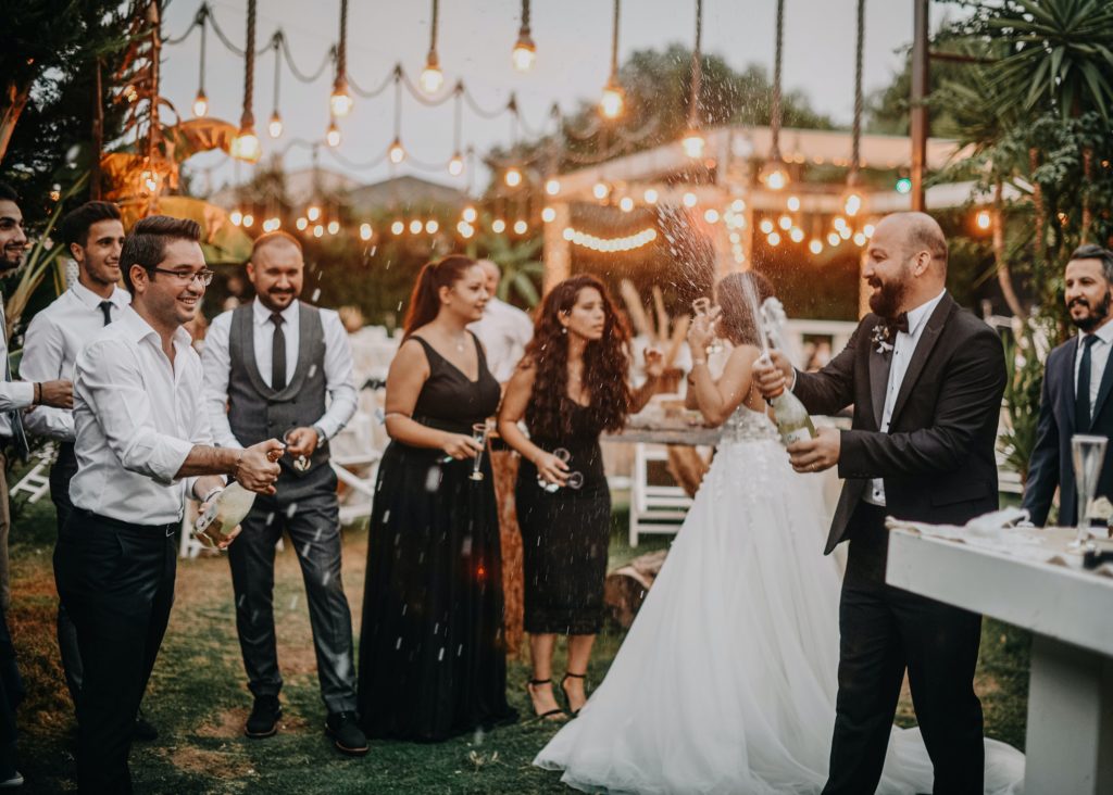 invitados y novios de una boda celebrando una fiesta y brindando con champán