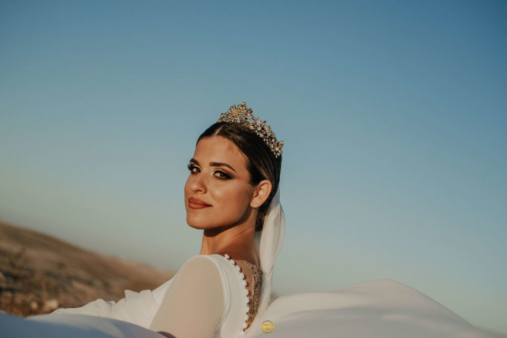 novia guapa que lleva una corona de pedrería posando en un campo sevillano para una boda organizada por la wedding planner flory ferreras