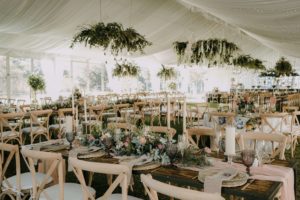 banquete de bodas decorado por la wedding planner flory ferreras con muebles en color crema y muchas plantas en centro de mesa y colgantes, muestra de qué hace una wedding planner